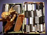 une statue en or représentant un singe tenant un skateboard à côté d'un tas de vieux téléphones portables