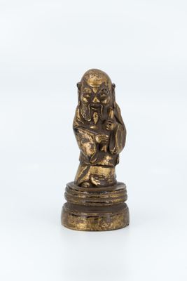 a bronze figurine of a monkey sitting on a rock