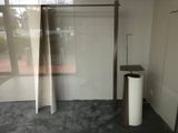 a glass shower stall with a toilet and a trash can