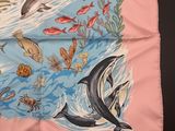 a pink scarf with a picture of animals and fish on it