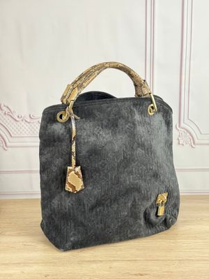 un sac à main noir et doré posé sur une table en bois