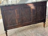 a wooden chest with a marble top on a brick floor