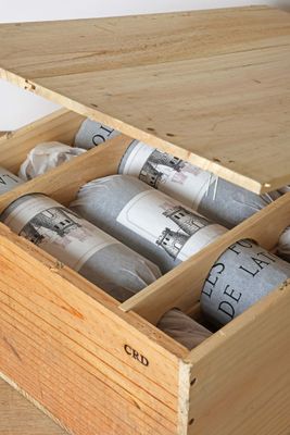 a wooden box filled with bottles of wine on top of a wooden table
