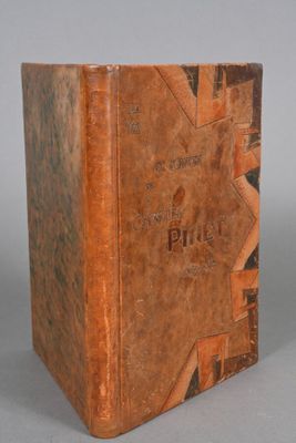 an old book sitting on top of a table next to a white wall