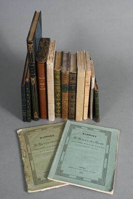 several old books are stacked on top of each other on a table