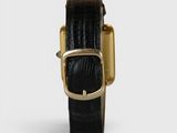 the gold buckle on the black leather watch is very elegant