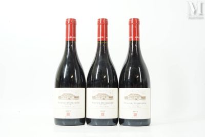trois bouteilles de vin rouge posées l'une à côté de l'autre sur une surface blanche