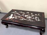a black table with flowers and birds painted on it