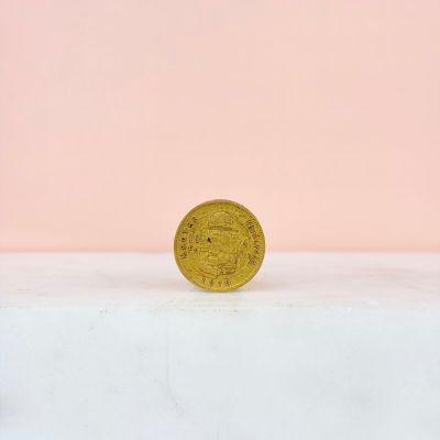 une pièce d'or posée sur une surface blanche