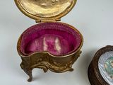 a small gold box with a picture inside of it