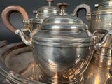 a silver tea set on a silver tray on a table