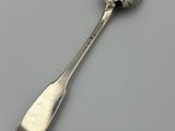 silver spoon on a white surface with a small spoon sticking out of it
