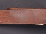a close up of a brown leather belt on a black surface