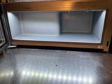 stainless steel counter top with two open shelves in a store
