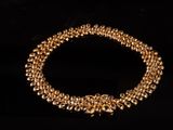 gros plan d'un collier en or sur fond noir