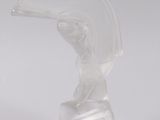 translucent glass sculpture of a woman holding a fan on a white surface