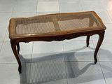 une table en bois avec un plateau en verre, posée sur un sol carrelé