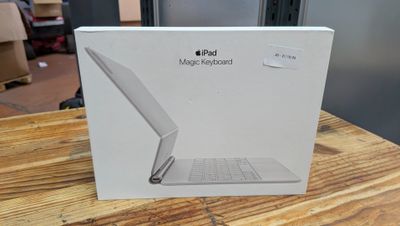boîte contenant un ordinateur portable MacBook Air de couleur pomme, posée sur une table en bois