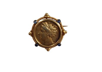 un gros plan d'une pièce de monnaie sertie dans une bague en or, sur fond blanc