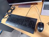 a keyboard and a mouse on a desk with a laptop
