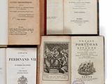 plusieurs vieux livres posés les uns sur les autres sur une surface blanche