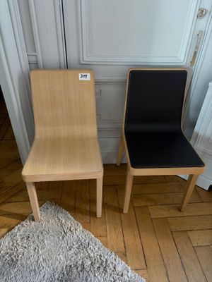 two wooden chairs sitting next to each other on the floor