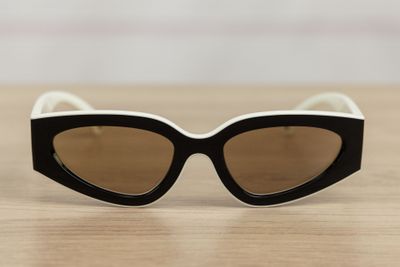 black and white cat eye sunglasses sitting on a wooden table