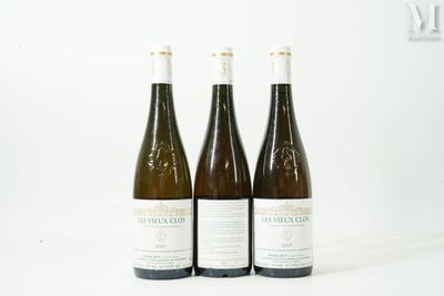 trois bouteilles de vin posées les unes à côté des autres sur une surface blanche