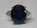 an image of a ring with a blue stone and diamonds