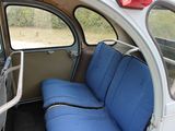 a seat in the back of a bus with a blue seat cover