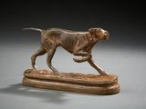 statue of a dog running on a wooden base on a gray surface