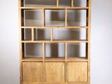 une photo d'une bibliothèque en bois posée contre un mur blanc