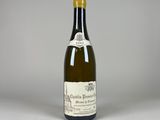 an old bottle of wine sitting on top of a white table