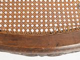 a close up of a wooden chair with holes in the back