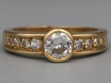 a close up of a gold ring with a white diamond on it