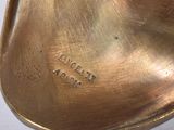 a close up of a brass object on a white surface