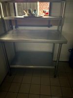 1 table en inox avec plateau d'entretoise et passe plat