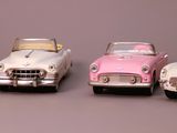 several toy cars are lined up in a row on a gray surface