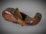 an old wooden plane with a wooden handle on a gray surface
