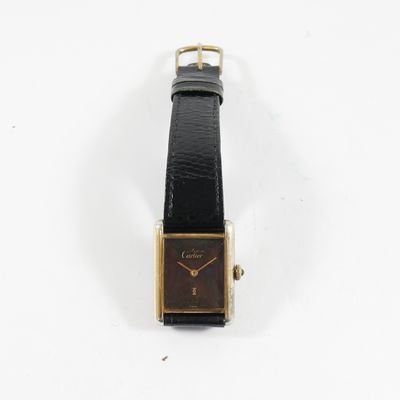 gros plan d'une montre sur une surface blanche avec un bracelet noir