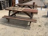 une table de pique-nique et un parasol installés sur le sable