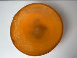 an orange bowl sitting on top of a white table