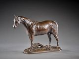 statue of a horse standing on a rock on a gray background