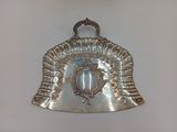 a silver purse hanging on a white wall