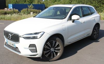 the white volvo suv is parked on the side of the road