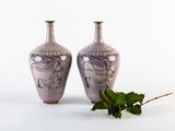 two vases sitting next to each other on a white surface