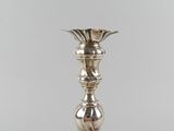 an image of a silver candle holder on a white surface