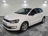 la volkswagen polo blanche est garée sur un carrelage à carreaux