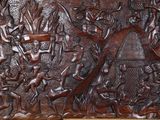 carved wood panel of a man and a woman in a forest
