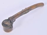 a small pipe with a handle on a white surface